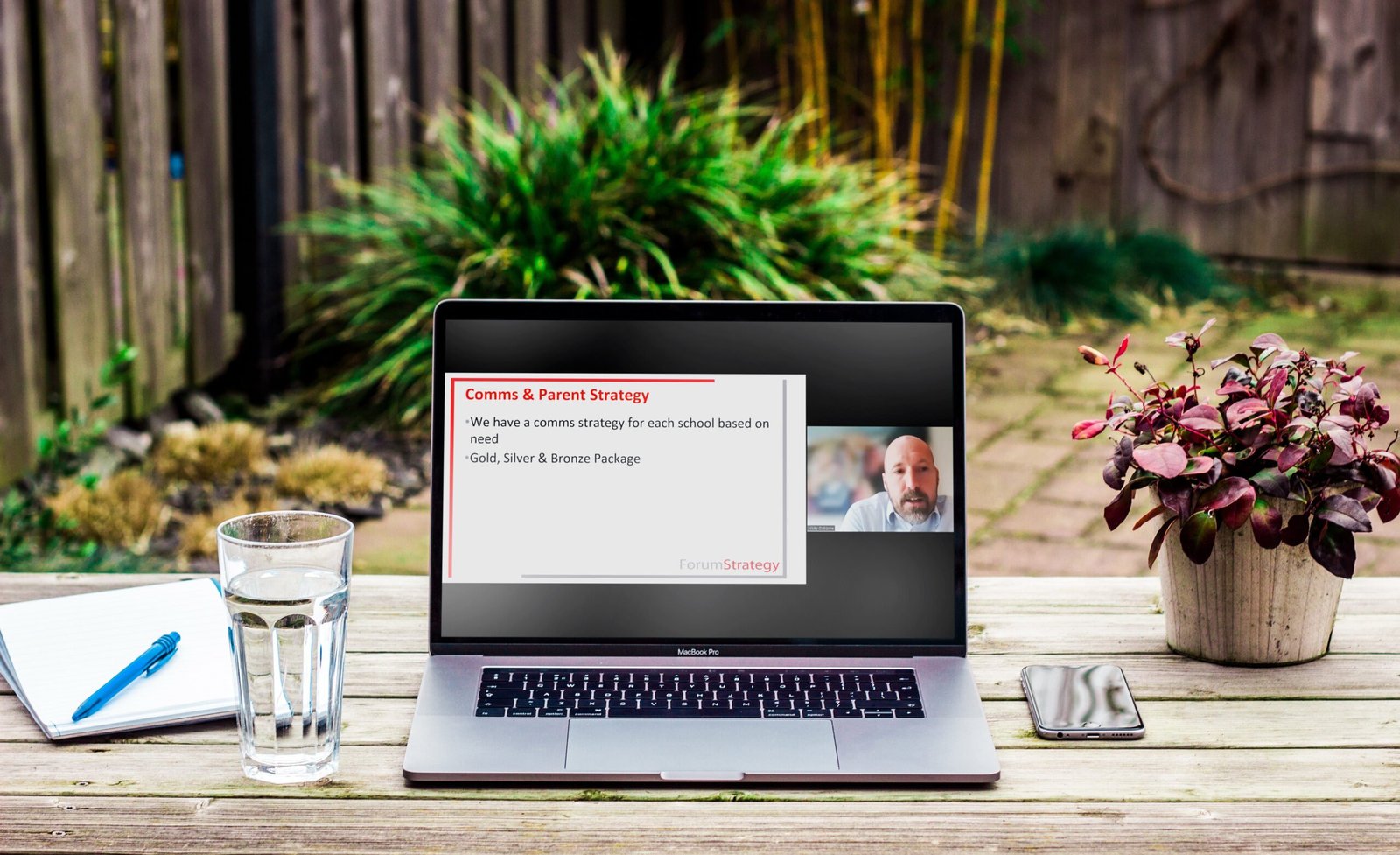 Image showing a laptop showing the Members Discussion Forum video playing, with a garden background